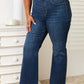 Woman wearing Judy Blue Jeans elastic waistband slim bootcut full size jeans in dark wash, paired with a white crop top.