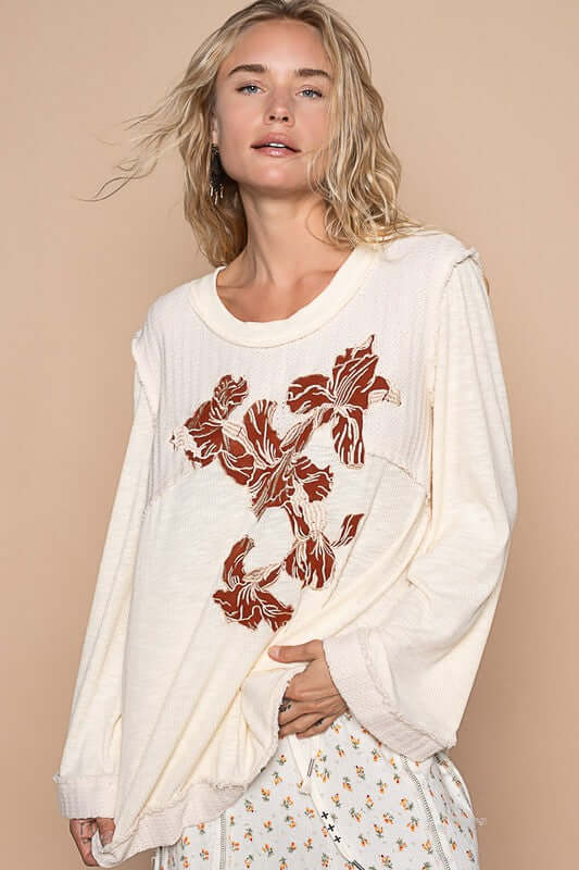 Model showcasing the POL Embroidered Round Neck Long Sleeve Knit Top with floral design on a neutral background.