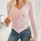 Woman wearing Bella Road Ribbed Drawstring Long Sleeve T-Shirt in light pink paired with blue jeans