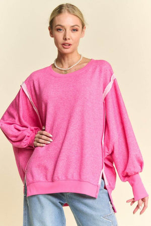 Trendy pink knit top with lantern sleeves and side zippers, perfect for a stylish casual look.