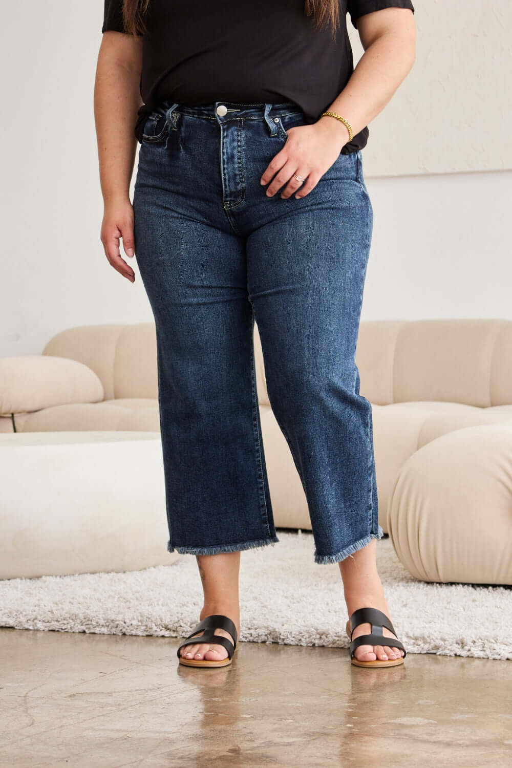 Woman wearing RFM Tummy Control High Waist Raw Hem Distressed Jeans for a sleek, trendy look with slimming fit.