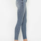 Woman wearing Judy Blue full size tummy control contrast wash skinny jeans with white sneakers, side view.