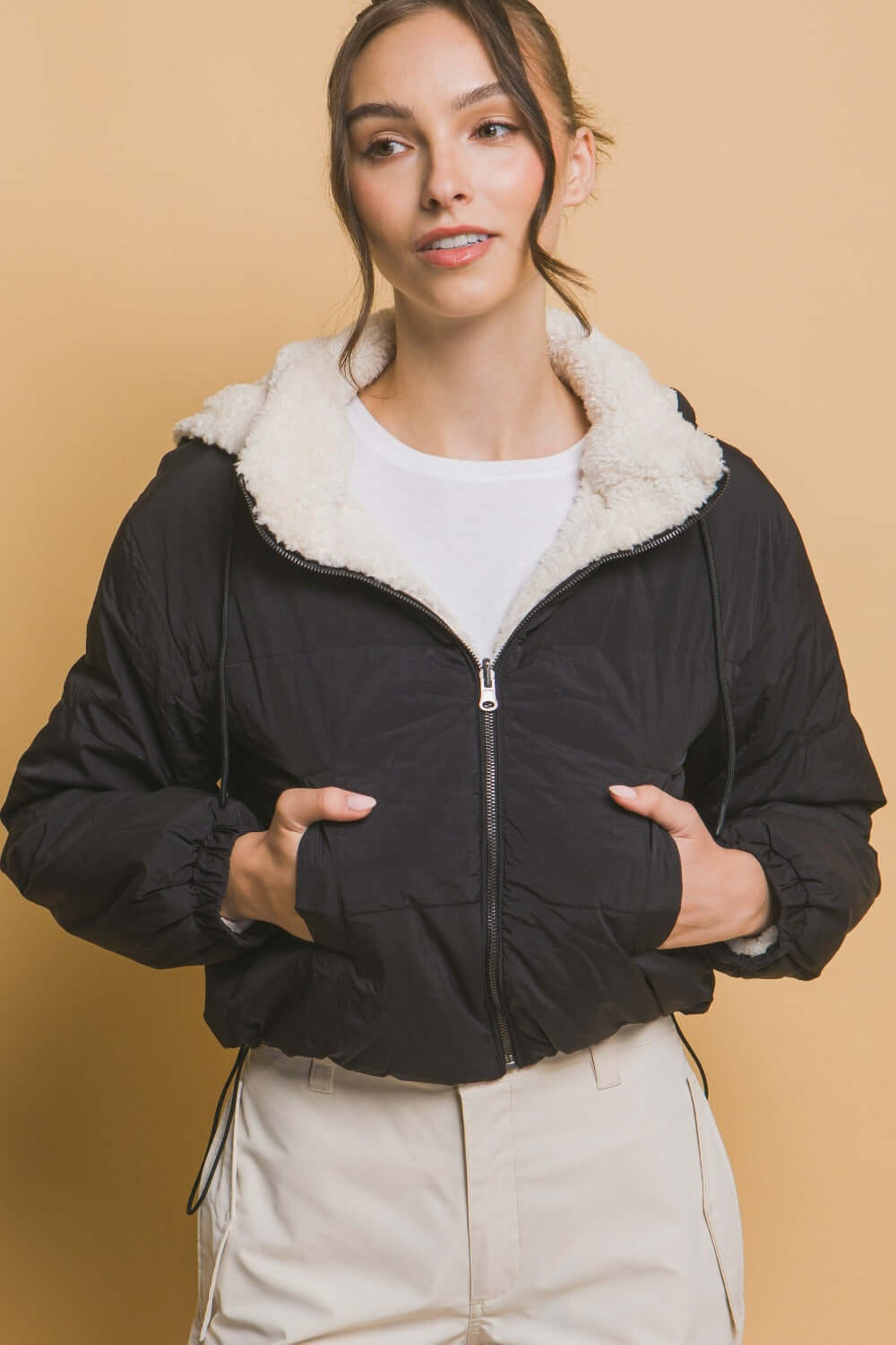 Woman wearing Love Tree Zip Up Cropped Hooded Sherpa Reversible Jacket, showcasing its stylish reversible design and cozy fit.