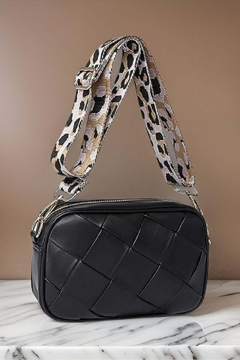 Stylish black Cassette Woven Crossbody Bag with a trendy leopard print strap, perfect for hands-free convenience.