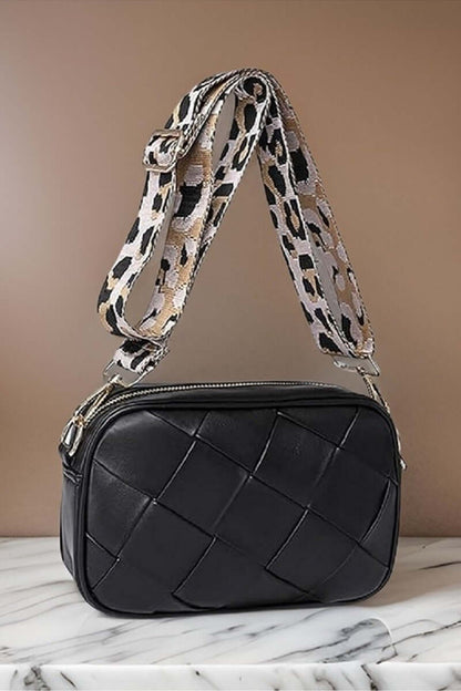 Stylish black Cassette Woven Crossbody Bag with a trendy leopard print strap, perfect for hands-free convenience.