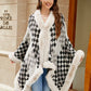 Stylish woman in a black and white fuzzy checkered poncho, perfect for cozy fall fashion.