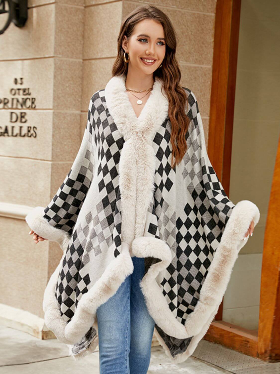 Stylish woman in a black and white fuzzy checkered poncho, perfect for cozy fall fashion.