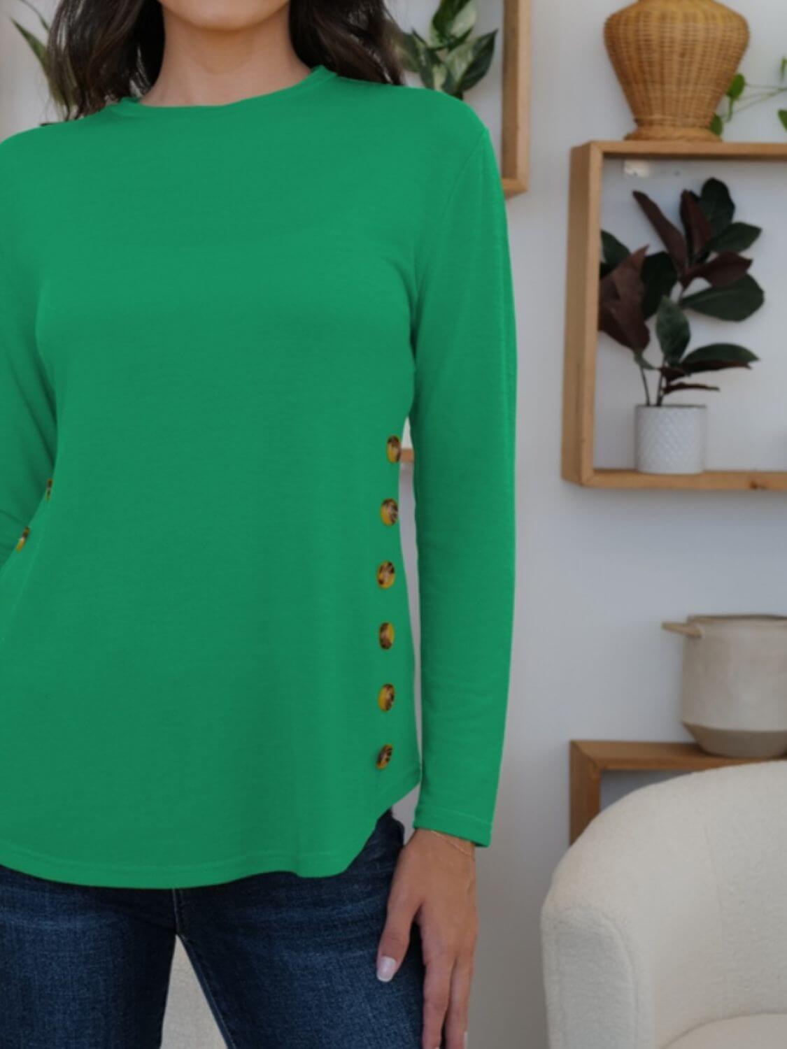 Woman wearing green FAM-FAM Round Neck Long Sleeve T-Shirt with decorative buttons, perfect for a fun and stylish casual look.