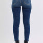 Back view of Judy Blue mid-rise skinny jeans featuring sleek pockets and a flattering fit, styled with ankle boots.