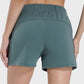 Back view of Millennia Elastic Waist Active Shorts in green, showcasing the comfortable elastic waistband and stretch fabric.