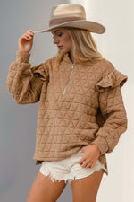 Woman wearing tan Double Take Ruffled Texture Half Zip Sweatshirt, paired with a hat and shorts for a stylish, cozy look.