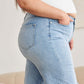 Woman wearing tummy control high waist raw hem distressed jeans by RFM Jeans, showcasing a flattering and supportive fit.