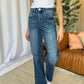 Woman wearing RFM Full Size High Rise Tummy Control Wide Leg Jeans in a relaxed, stylish setting