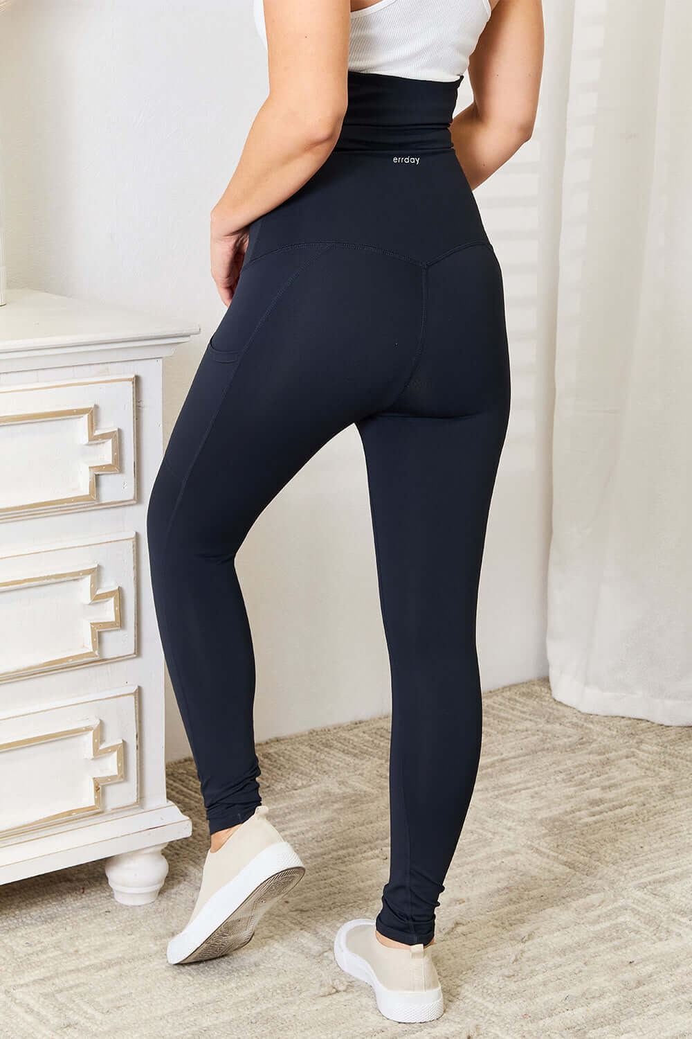 Woman wearing Heimish Full Size Waist Trainer Corset Leggings in black, showing high-waisted design and sleek fit from the back.