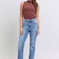 Stylish woman wearing Judy Blue high rise bootcut jeans with a raw hem and a trendy brown sleeveless top.