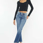 Woman modeling Kancan High Rise Wide Waistband Slim Straight Jeans with frayed hem and stretchy denim in medium stone wash.