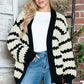 Woman wearing Bella Road Striped Contrast Open Front Long Sleeve Cardigan with black and white design, styled casually with jeans.