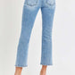 Woman wearing low rise crop slim straight jeans with raw hem and pocketed design, paired with black heels.