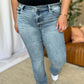 Woman wearing Judy Blue medium rise bootcut jeans, showcasing timeless style and comfortable fit for all body types.