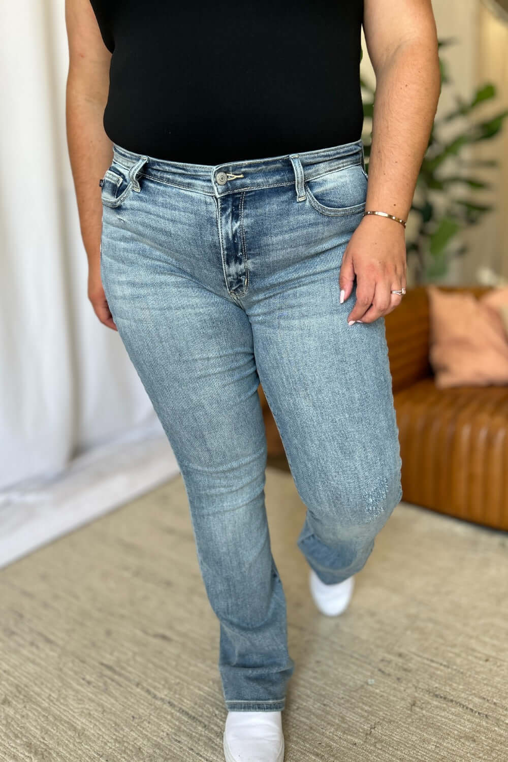 Woman wearing Judy Blue medium rise bootcut jeans, showcasing timeless style and comfortable fit for all body types.