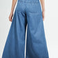 Woman wearing drawstring elastic waist wide leg jeans made of 100% cotton, showing back view and high-waisted design.