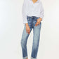 Woman wearing high rise cuffed straight jeans with white blouse and heels