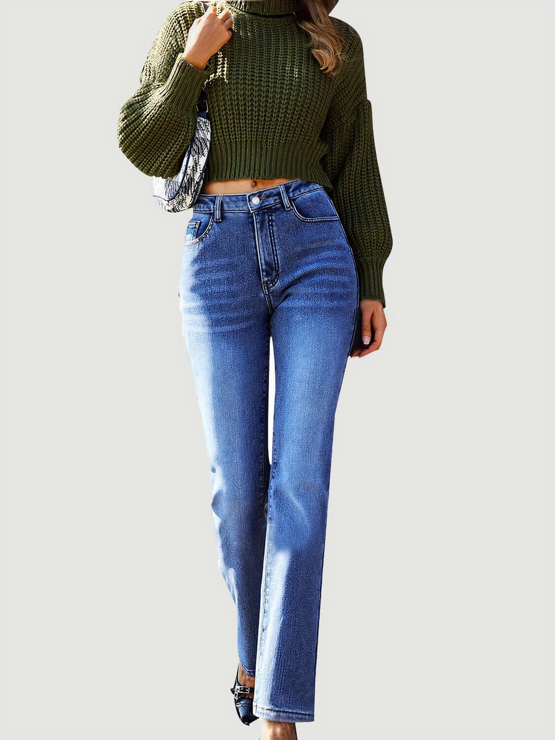 Woman wearing Bella Road Straight Leg Jeans with spacious pockets, paired with a green knitted sweater.