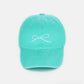 Mint green cotton cap with delicate bow embroidery, offering a stylish and comfortable fit.