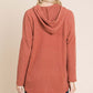 Back view of a relaxed-fit knit hoodie with a drawstring hood and dropped shoulders, perfect for casual layering.