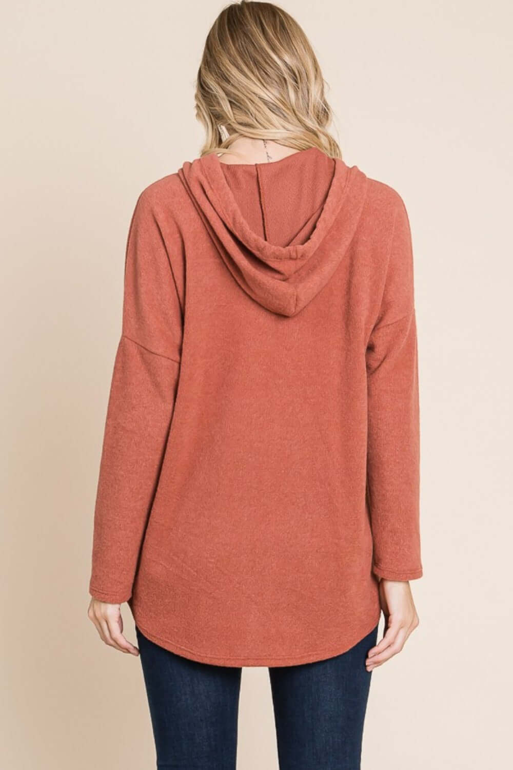 Back view of a relaxed-fit knit hoodie with a drawstring hood and dropped shoulders, perfect for casual layering.