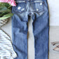 Distressed printed straight jeans in blue color with back view, surrounded by flowers and stripped cloth, perfect for adding unique touch to denim collection