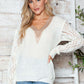 Woman wearing Bella Road Openwork V-Neck Long Sleeve Sweater, cozy and stylish knit perfect for fashionable warmth.