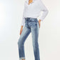 Woman wearing high rise cuffed straight jeans with a white blouse and heels