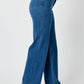 Side view of model wearing high-rise straight Judy Blue jeans in blue paired with casual shoes.