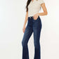 Woman wearing Kancan full size mid rise slim flare jeans in dark stone wash, showcasing a flattering silhouette and comfy fit.