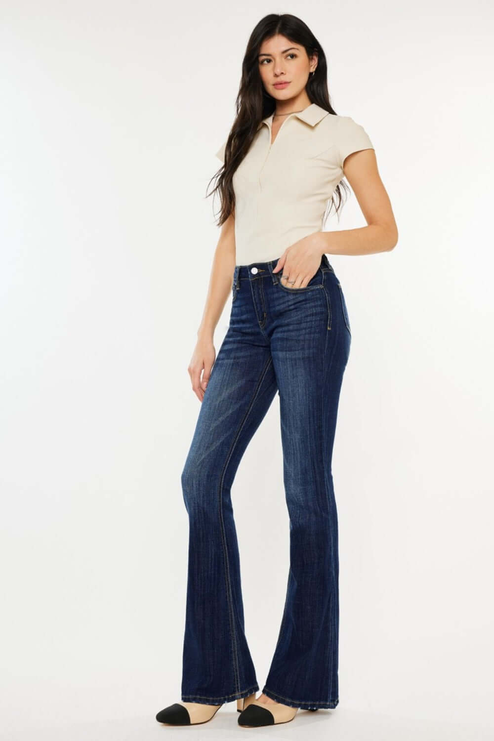 Woman wearing Kancan full size mid rise slim flare jeans in dark stone wash, showcasing a flattering silhouette and comfy fit.