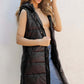 Woman modeling Bella Road Longline Hooded Sleeveless Puffer Vest in black, perfect for layering and outdoor adventures.