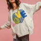 Charming model in LOVE Heart Patch Slit French Terry Sweatshirt with stylish slit and colorful patch on pink background.