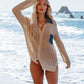 Woman in openwork collared cover-up standing by the beach, embodying summer style with sun-kissed confidence.