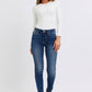 Model wearing Judy Blue mid-rise waist skinny jeans and a white long-sleeve top, showcasing a sleek and stylish look.