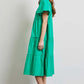 Woman wearing green HEYSON Cotton Poplin Ruffled Tiered Midi Dress, side view, showcasing elegant ruffles and a flattering silhouette.