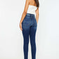 Woman wearing Kancan high-rise ankle skinny jeans with double waistband and release hem, showcasing trendy dark wash denim style.