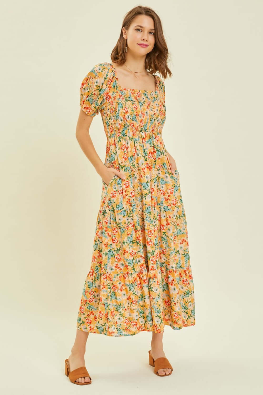 Woman wearing a HEYSON floral smocked tiered midi dress, perfect for summer occasions, showcasing a charming and feminine style.