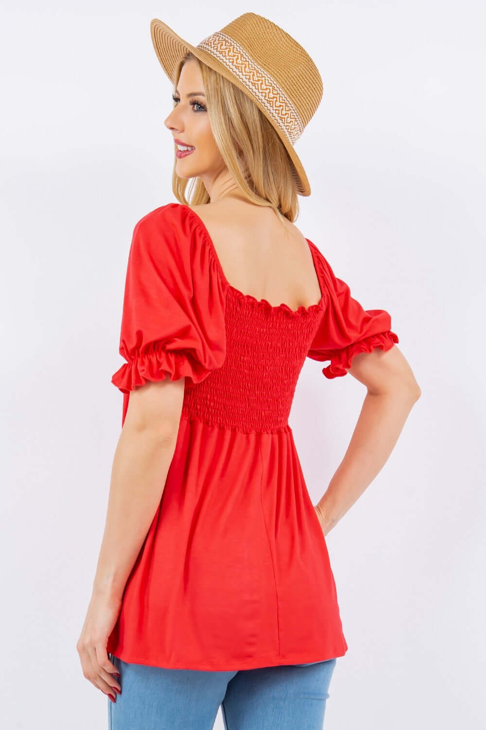 Woman wearing red ruffled short sleeve smocked blouse with hat.