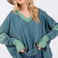 Woman wearing Mineral Wash Side Slit Contrast Top with V-neck and long sleeves, showcasing trendy and textured design elements.