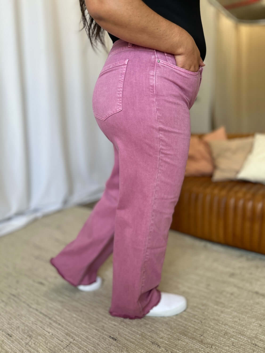 Woman wearing RFM Full Size High Rise Garment Dye Wide Leg Jeans in pink, showcasing high-waist fit and relaxed, wide-leg silhouette.