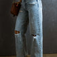 Petite distressed raw hem straight jeans with no stretch, featuring a trendy and playful fit, paired with sandals and a red top.