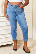 Woman wearing high waist skinny Judy Blue jeans in medium ash wash with brown ankle boots, showcasing clean and polished look