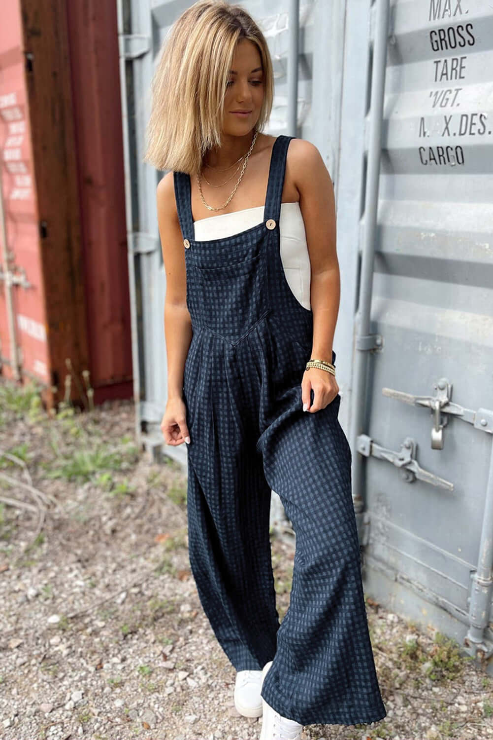 Woman wearing Bella Road Plaid Wide Leg Overalls with wide straps, standing outdoors in trendy casual style.