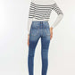 High Waist Distressed Raw Hem Ankle Skinny Jeans styled with a striped sweater, showcasing a trendy cropped look and rebellious vibe.